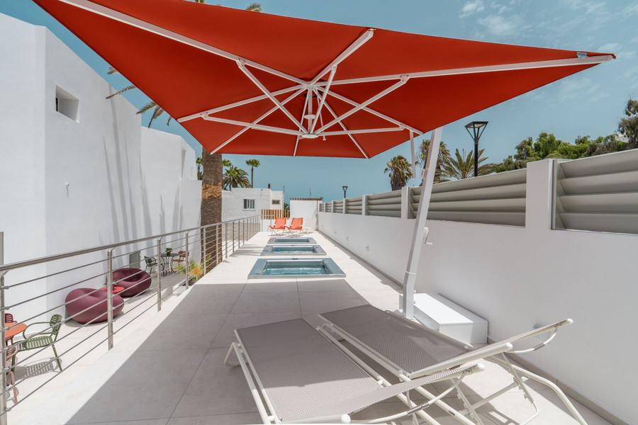 Solarium con ombrellone rosso e jacuzzi