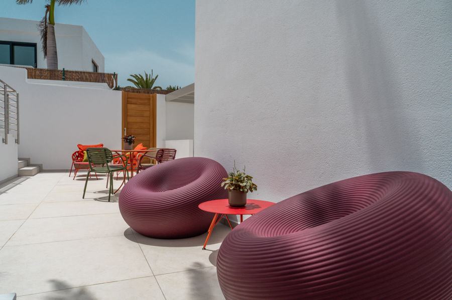 Pouf color prugna accanto alla palma